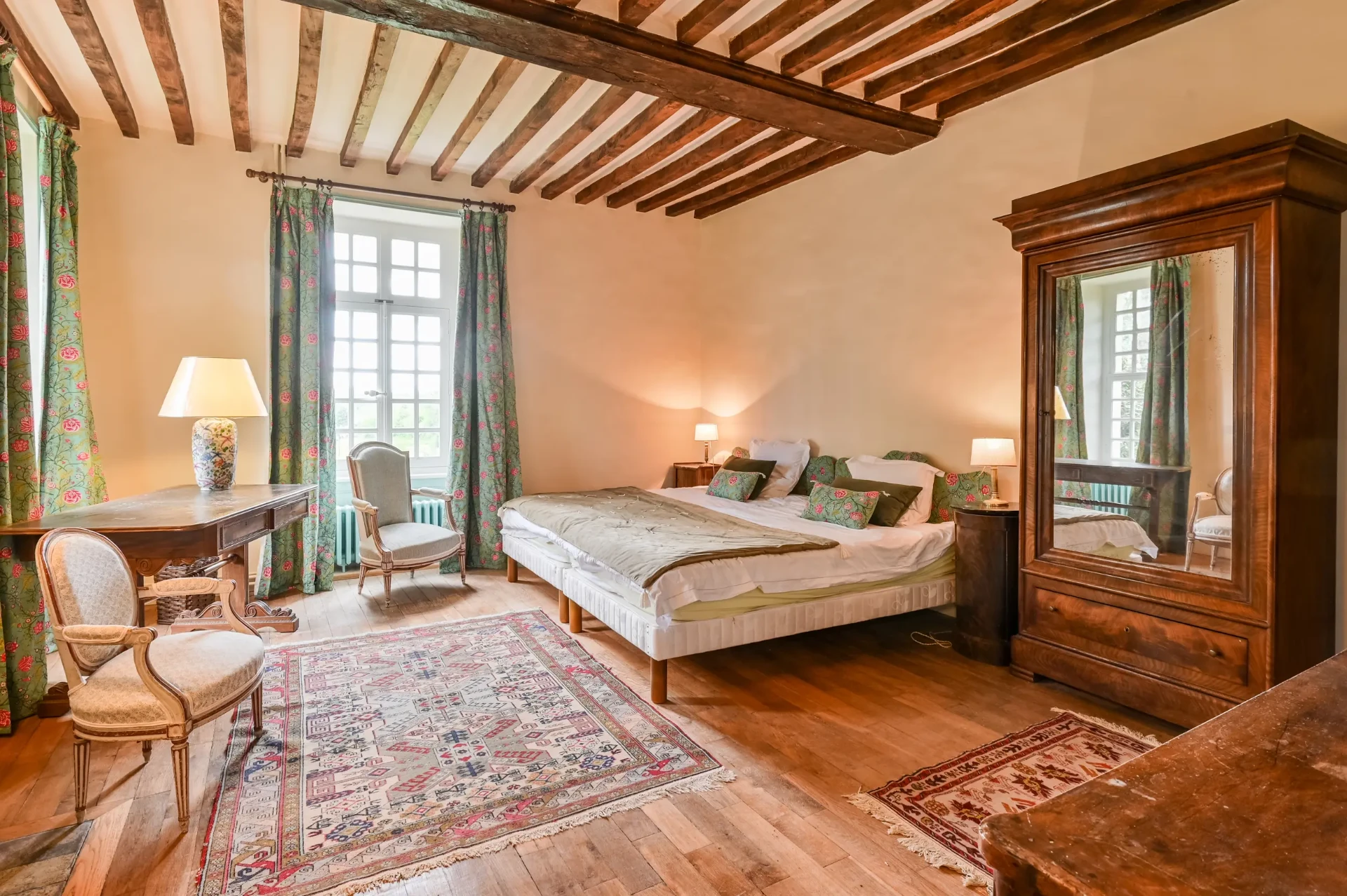 Chambre aux rideaux fleuris, poutres et armoire Louis-Philippe